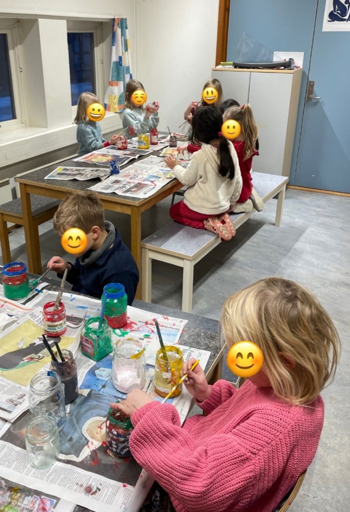 barn som sitter ved et bord og maler