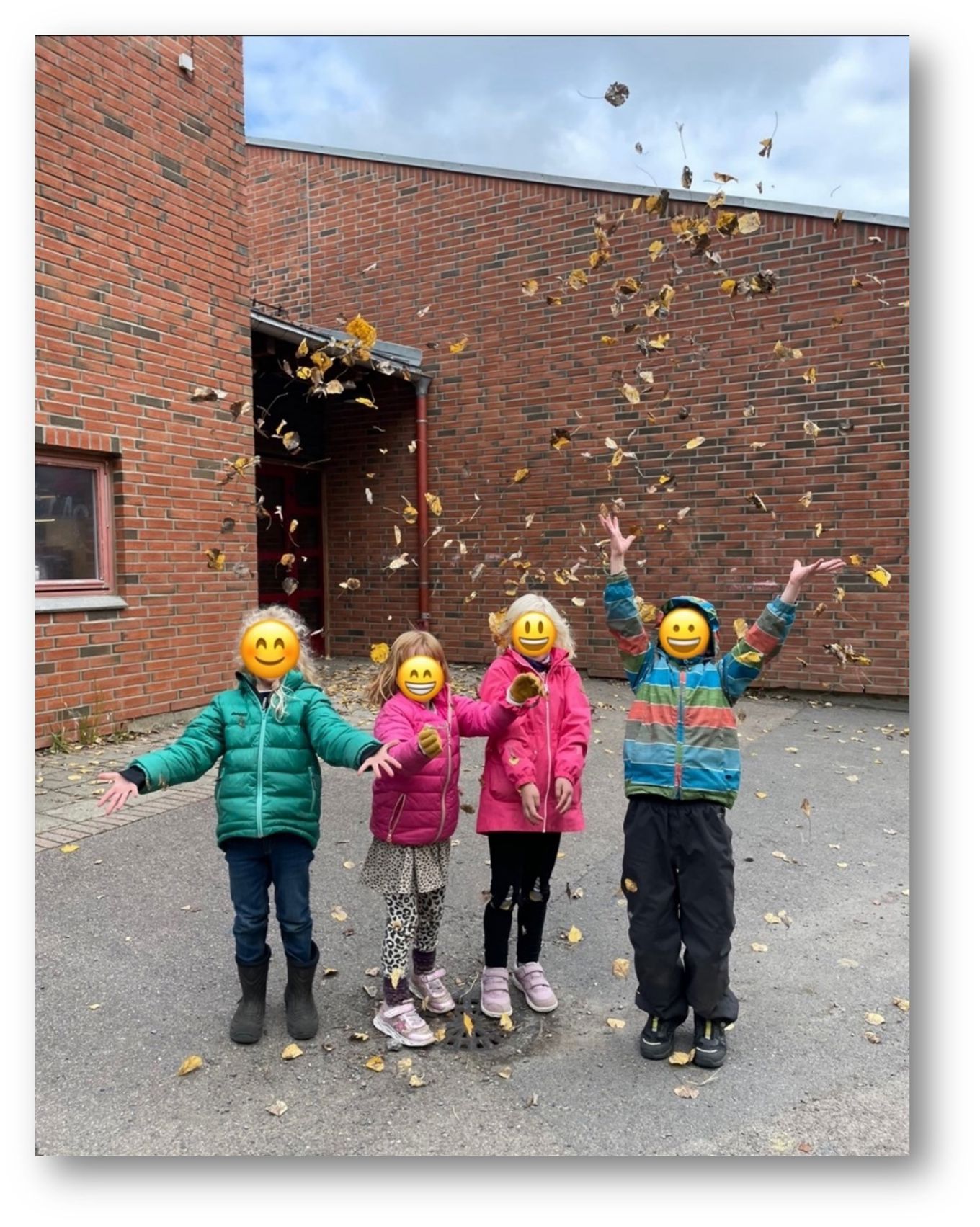 en gruppe barn som kaster høstløv i været