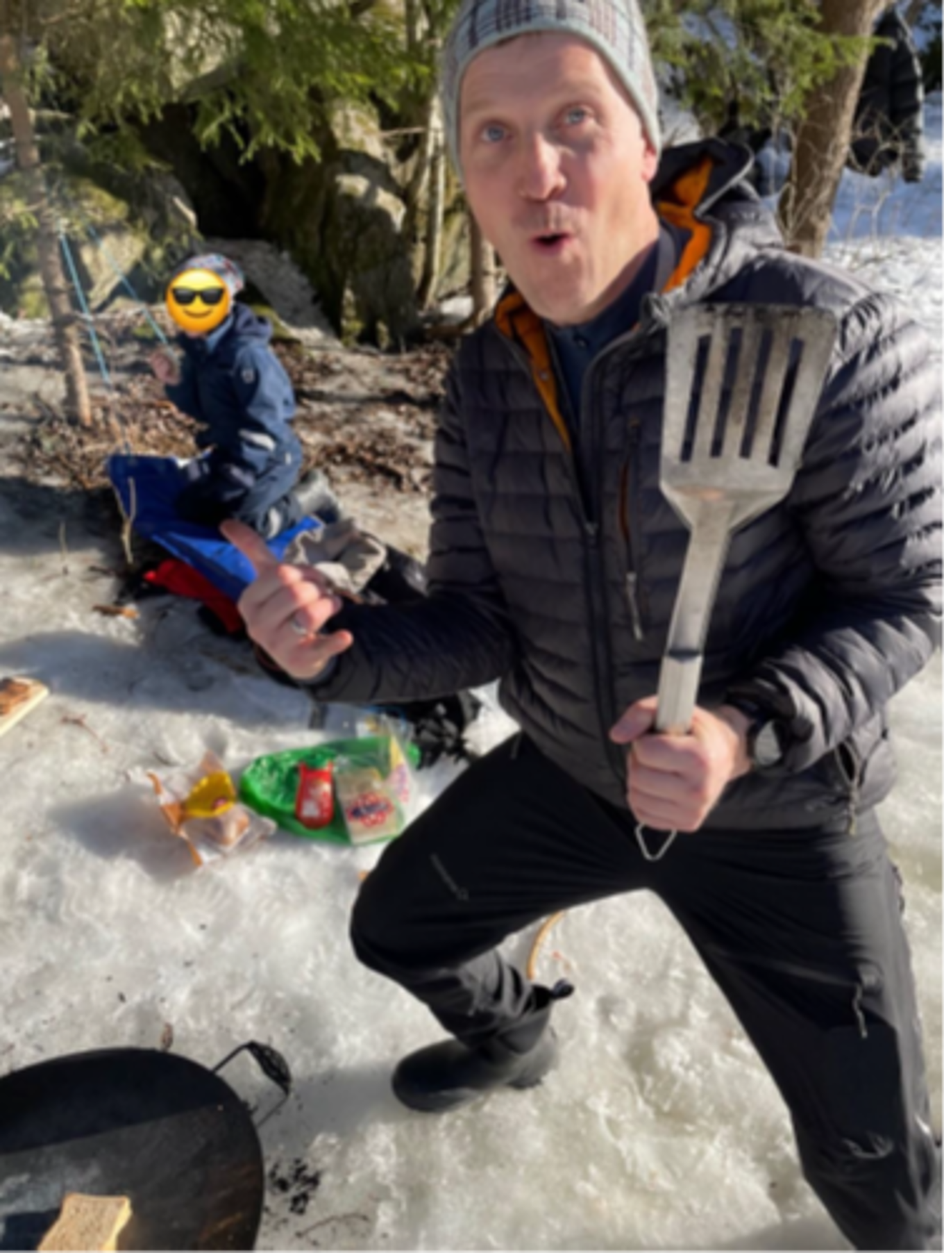 En ansatt på AKS som griller på bålpanne i skogen