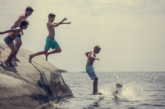 en gruppe mennesker som hopper i vannet