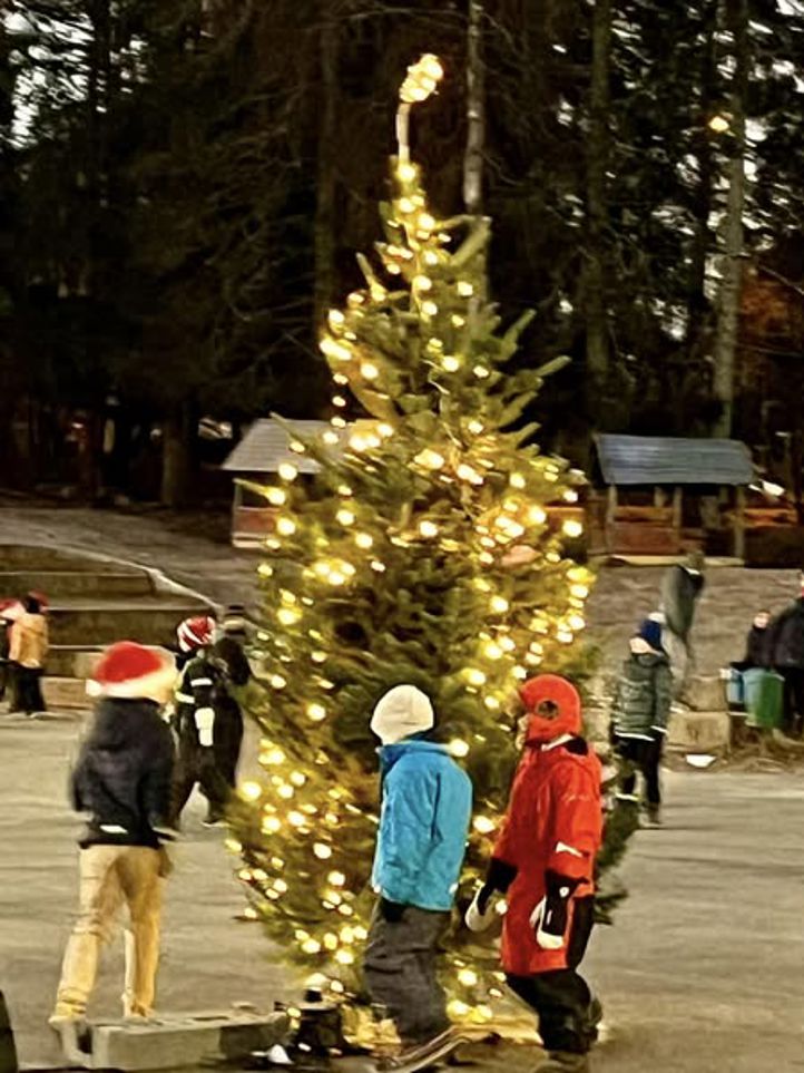 Eleversom går rundt et juletre som står i skolegården